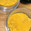 Fine yellow crystalline extract powder inside a clear glass laboratory vial