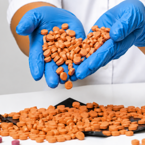 Several round orange botanical tablets arranged on a rustic wooden table surface