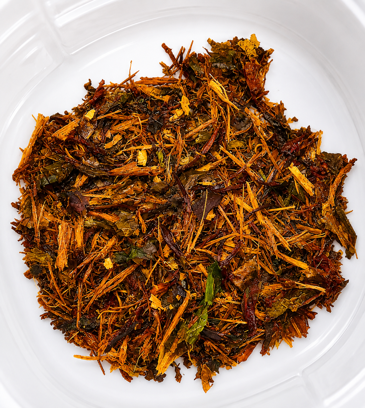 Premium loose herbal smoking blend containing shredded aromatic botanicals inside a clear container